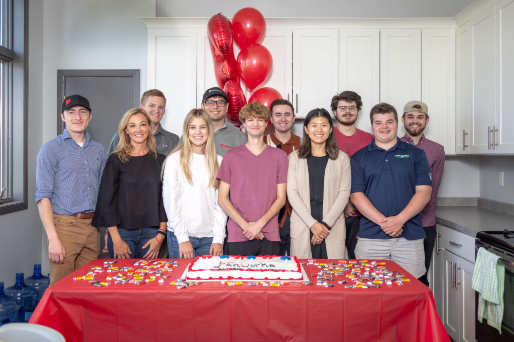 Fenworks Staff members surrounding a three-year birthday cake to commemorate the third anniversary of Fenworks Esports and Drone Racing.